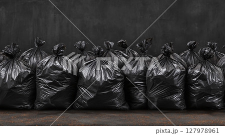 Collection of black garbage bags filled with waste against a dark background. Dark and ominous scene symbolizing disposal, environmental concerns. 127978961