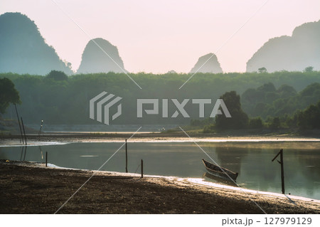 boat on Nong Thale swamp with limestone mountains at sunrise, Krabi 127979129