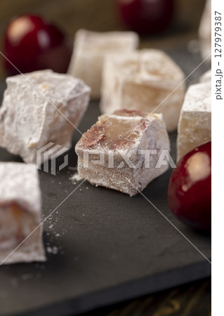 cubes of Turkish delight with the addition of dried red berries in powdered sugar closeup cubes of Turkish delight with the addition of dried red berries in powdered sugar closeup 127979387