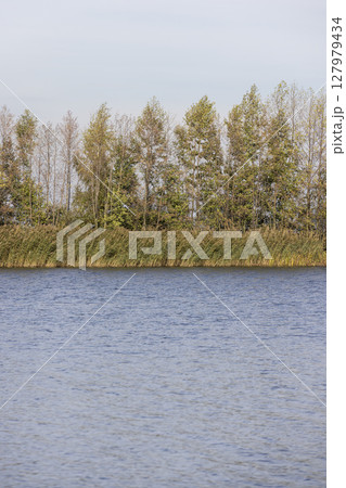 a lake in cloudy weather during the autumn with waves on the water a lake in cloudy weather during the autumn with waves on the water 127979434