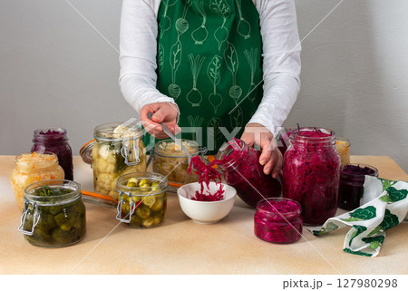 Woman fermenting fresh vegetables Woman fermenting fresh vegetables 127980298