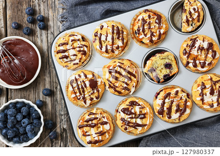 tasty blueberry muffins with lemon chocolate glaze 127980337