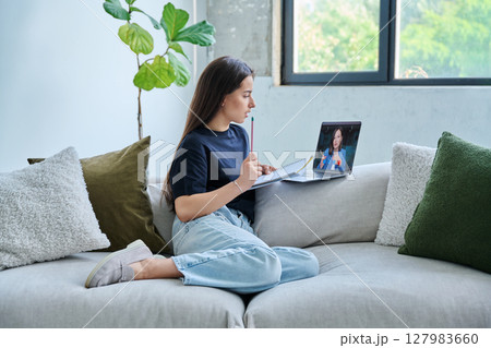 Teenage girl student having online lesson, watching webinar, at home Teenage girl student having online lesson, watching webinar, at home 127983660