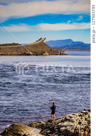 Angler with fishing rod on Atlantic road, Norway Angler with fishing rod on Atlantic road, Norway 127983795