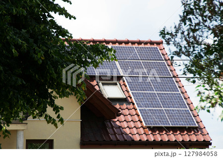 Installing a Solar Cell on a Roof. Solar panels on roof. Historic farm house with modern solar panels on roof and wall. High quality photo Installing a Solar Cell on a Roof. Solar panels on roof. Historic farm house with modern solar panels on roof and wall. High quality photo 127984058