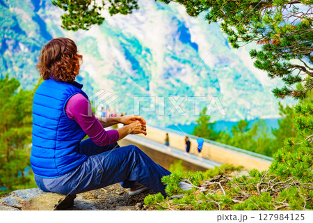Tourist enjoying mountains fjord view, Norway Tourist enjoying mountains fjord view, Norway 127984125