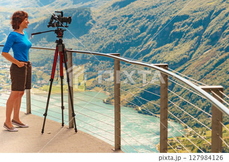 Tourist with camera on tripod in Norway nature 127984126