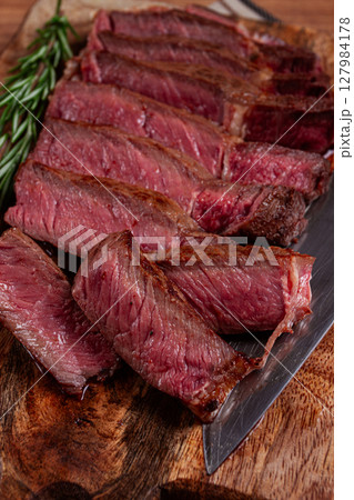 fried steak, beef steak, rib eye steak, sliced steak, on a chopping board, top view, no people 127984178