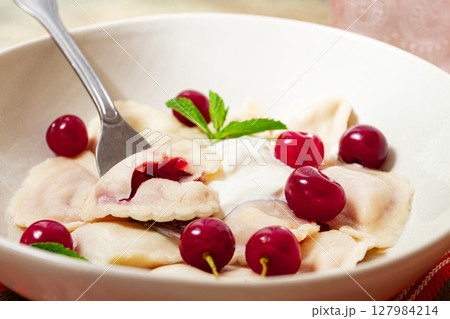 Traditional dumplings with cherries and yogurt, close-up, no people, 127984214