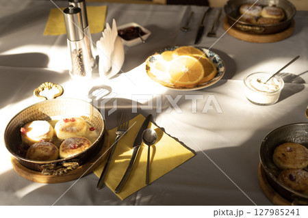 served table cottage cheese pancakes with pomegranate and orange slices 127985241