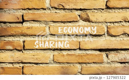 Sharing economy symbol. Concept words Sharing economy on beautiful brown brick wall. Beautiful brown brick wall background. Business sharing economy concept. Copy space. 127985322