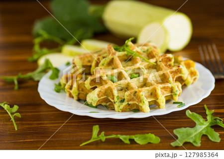 Homemade zucchini waffles with green onions on a wooden table Homemade zucchini waffles with green onions on a wooden table 127985364