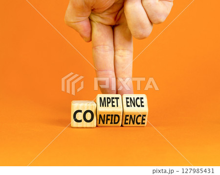 Competence and confidence symbol. Concept word Competence Confidence on wooden cubes. Businessman hand. Beautiful orange table orange background. Business competence confidence concept. Copy space. 127985431