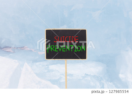 Suicide prevention symbol. Concept words Suicide prevention on beautiful black yellow blackboard. Beautiful blue ice background. Psychological and suicide prevention concept. Copy space. 127985554