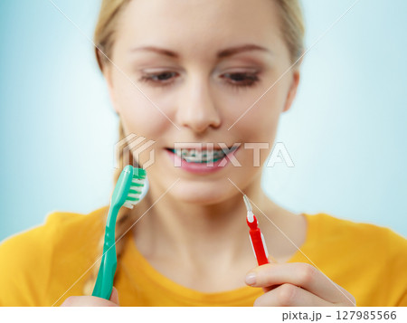 Girl with teeth braces using interdental and traditional brush Girl with teeth braces using interdental and traditional brush 127985566