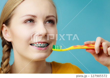 Woman with teeth braces using brush Woman with teeth braces using brush 127985572