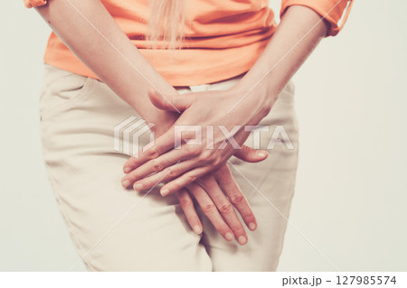 woman with hands holding her crotch woman with hands holding her crotch 127985574