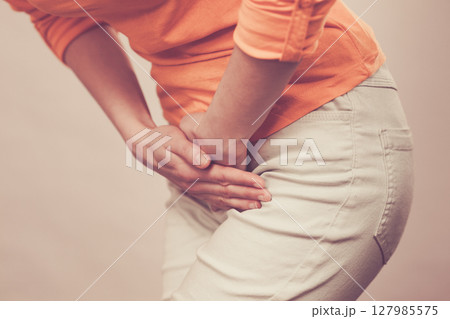 woman with hands holding her crotch woman with hands holding her crotch 127985575