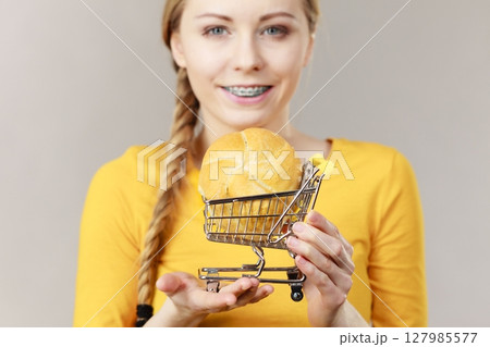 Woman holding shopping cart with bread 127985577