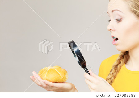 Shocked woman magnifying bun bread roll Shocked woman magnifying bun bread roll 127985588