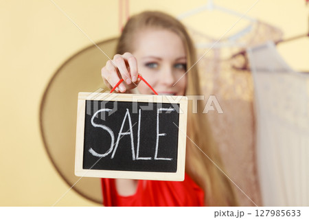 Woman in shop picking clothes, sale concept Woman in shop picking clothes, sale concept 127985633