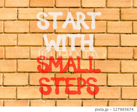 Start with small steps symbol. Concept words phrase Start with small steps on beautiful brown brick wall. Beautiful brown brick wall background. Business Start with small steps concept. Copy space. 127985674