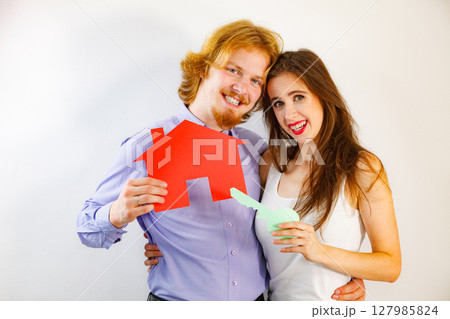 Couple holding real estate paper symbols Couple holding real estate paper symbols 127985824