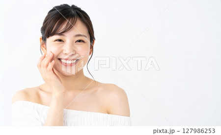 頬に手を添えて微笑む若い女性 頬に手を添えて微笑む若い女性 127986253