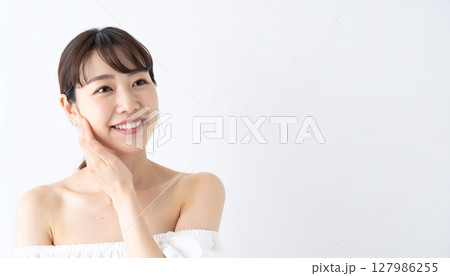 頬に手を添えて微笑む若い女性   127986255