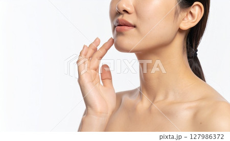 頬に手を添えて微笑む女性のスキンケア 127986372