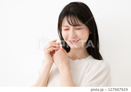 白い背景の前で笑顔の女性 白い背景の前で笑顔の女性 127987929