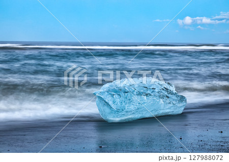 Excellent pieces of iceberg sparkle on famous Diamond Beach at  Jokulsarlon lagoon during sunset. 127988072