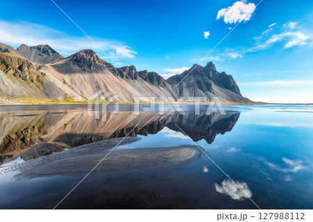 Impressive  sunny day and gorgeous reflection of Vestrahorn mountaine on Stokksnes cape in Iceland. 127988112