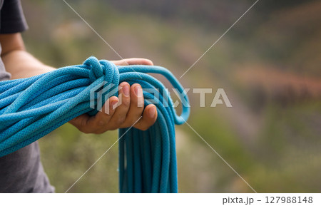 Man with a rope climbing in the mountains. Technical mountaineering. Man with a rope climbing in the mountains. Technical mountaineering. 127988148