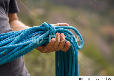 Man with a rope climbing in the mountains. Technical mountaineering. Man with a rope climbing in the mountains. Technical mountaineering. 127988150