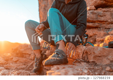 girl puts on special climbing shoes on her legs before climbing o 127988159