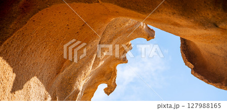 A rock, desert sandy formations, a natural arch Arco de las Penitas in the daylight. 127988165