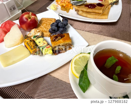フルーツとお菓子が並ぶブハラの朝食 127988182