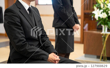 葬儀で静かに座る男女 127988629