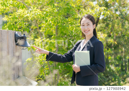 住宅を訪問するスーツの女性 住宅を訪問するスーツの女性 127988942