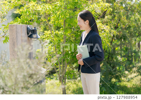 住宅を訪問するスーツの女性 住宅を訪問するスーツの女性 127988954