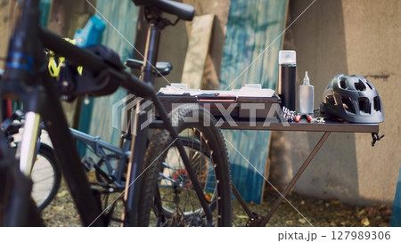 Glimpse of expert toolkit neatly arranged on table alongside an assortment of other tools and a helmet all set for outdoor bike maintenance. Specialized equipment ready for bicycle repair. 127989306