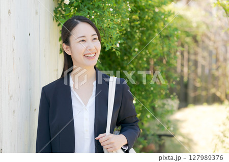 新緑の中に立つビジネスウーマン 新緑の中に立つビジネスウーマン 127989376