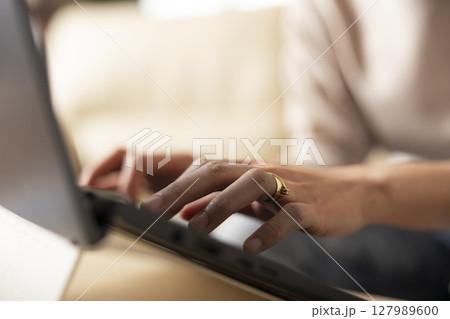 Close up of female hands typing on laptop keyboard, replying to work emails from home. Selective focus showing remote work routine with individual updating business reports and project proposals. Close up of female hands typing on laptop keyboard, replying to work emails from home. Selective focus showing remote work routine with individual updating business reports and project proposals. 127989600