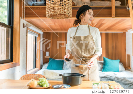 家族旅行・コテージ・バンガローで食事の支度をする母親・ママ・主婦 127989775