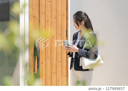 ドアの施錠をするスーツの女性 ドアの施錠をするスーツの女性 127989857