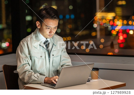 夜のオフィスでパソコンを使う作業員 127989928