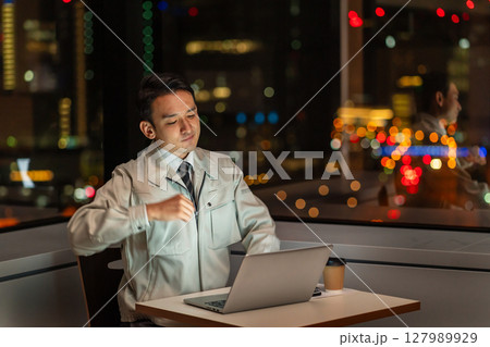 夜のオフィスでパソコンを操作する作業員 127989929