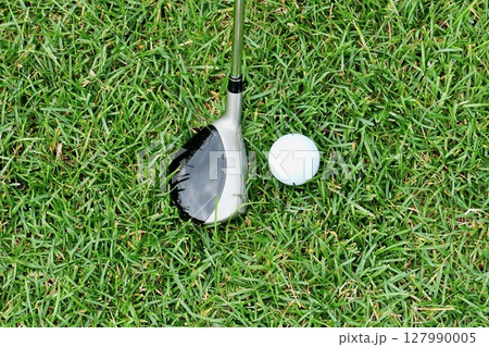 芝生「ラフ」上の白いゴルフボールとスプーン 127990005
