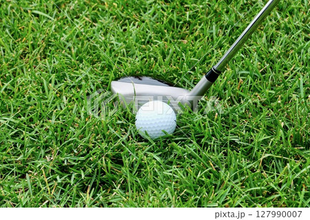芝生「ラフ」上の白いゴルフボールとスプーン 127990007